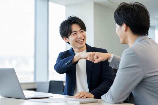 オフィスでグータッチする同僚