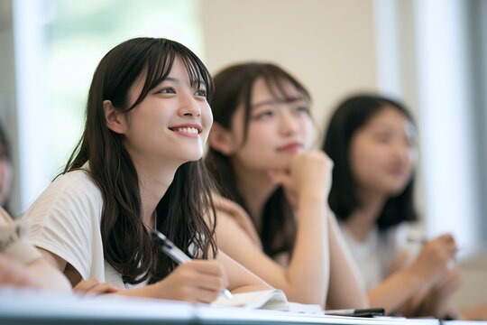 教室で前を向いて学ぶ大学生